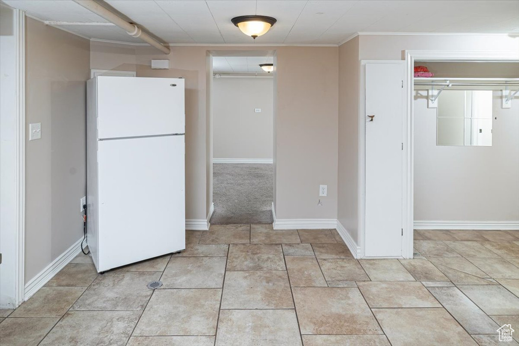 Kitchen featuring light tile floors and white fridge
