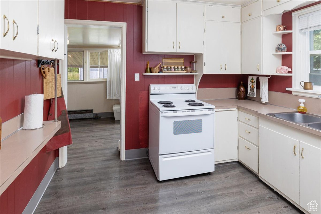 Kitchen featuring white cabinets, white electric stove, and hardwood / wood-style floors