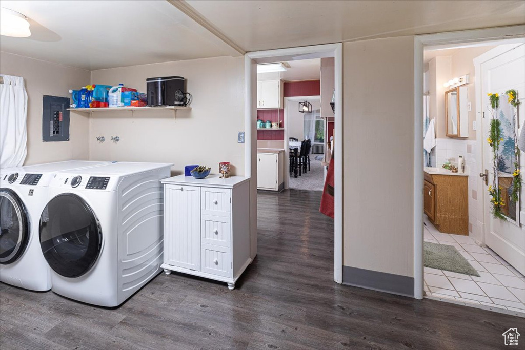 Clothes washing area featuring dark tile floors and washer and dryer