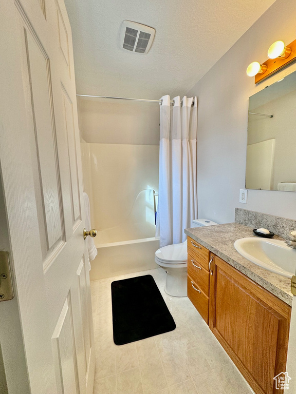 Full bathroom with toilet, vanity, shower / tub combo, and tile flooring