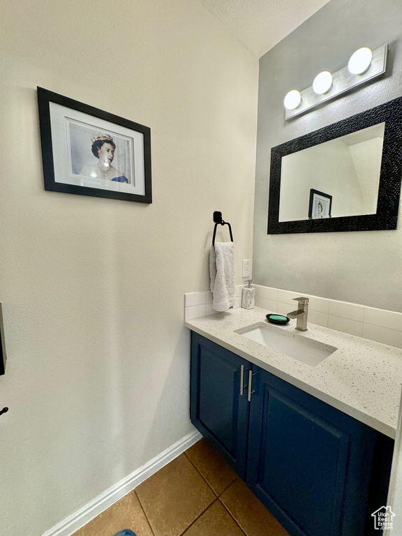 Bathroom with vanity with extensive cabinet space and tile flooring