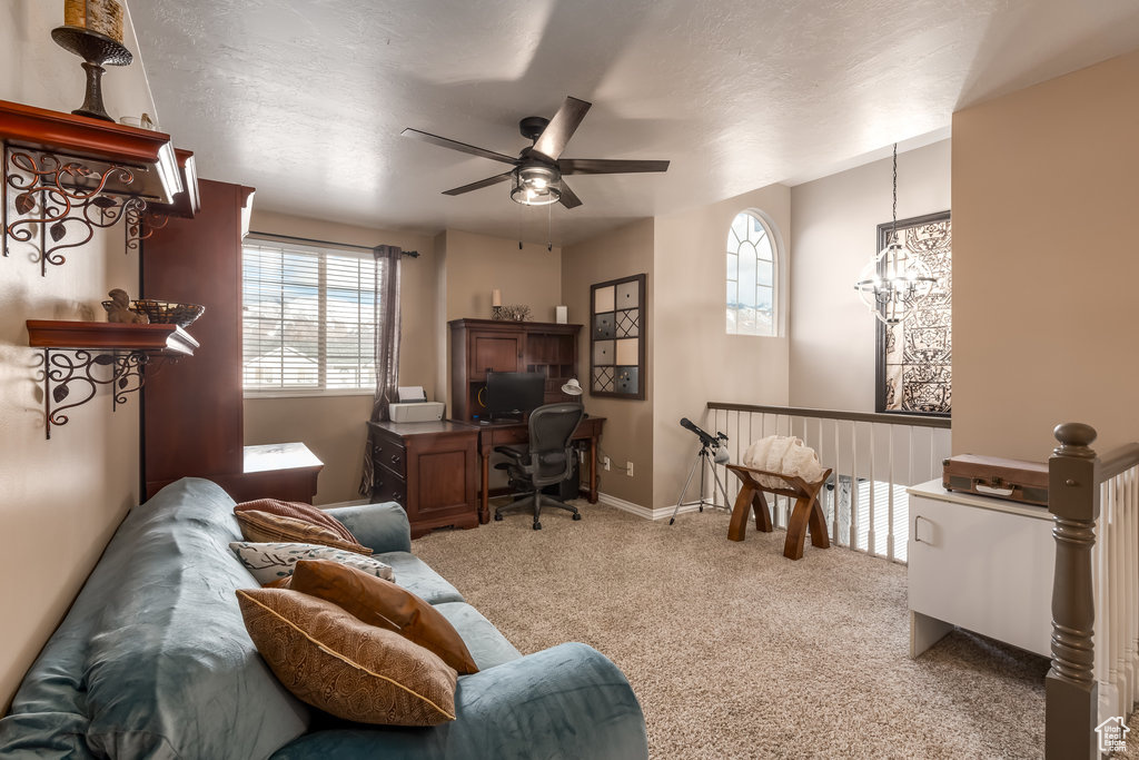 Living area with ceiling fan and light colored carpet