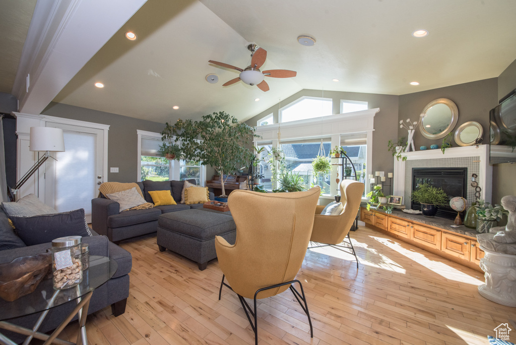 Living room with light hardwood / wood-style flooring, vaulted ceiling, and ceiling fan