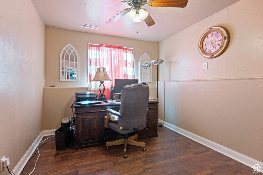 Home office with dark wood-type flooring and ceiling fan