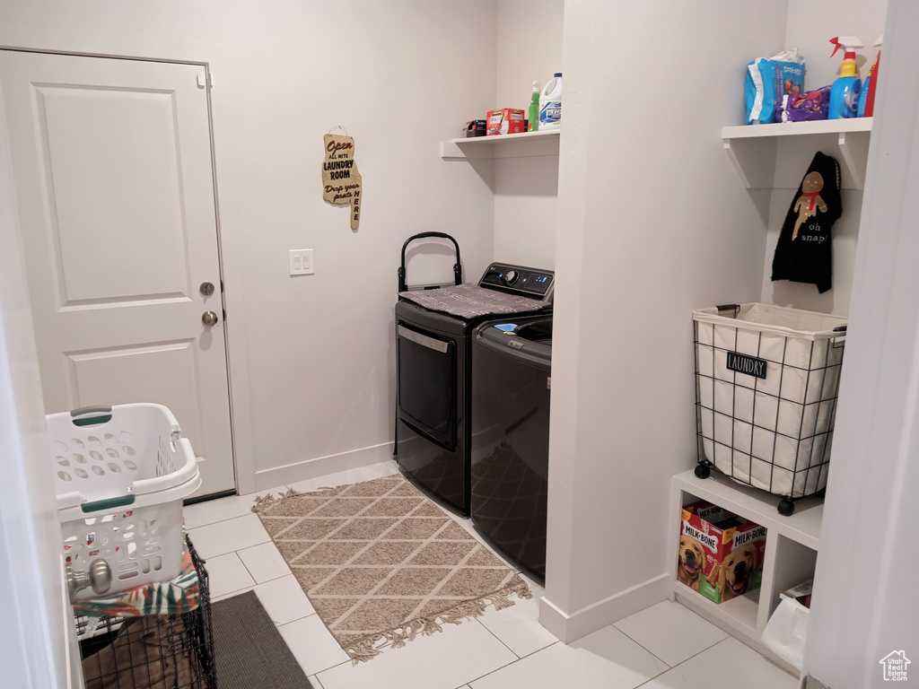 Laundry room featuring separate washer and dryer and light tile flooring