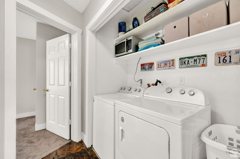Laundry room featuring independent washer and dryer and dark colored carpet