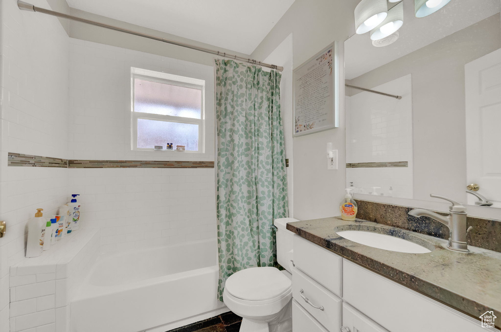 Full bathroom featuring tile floors, toilet, shower / tub combo, and vanity