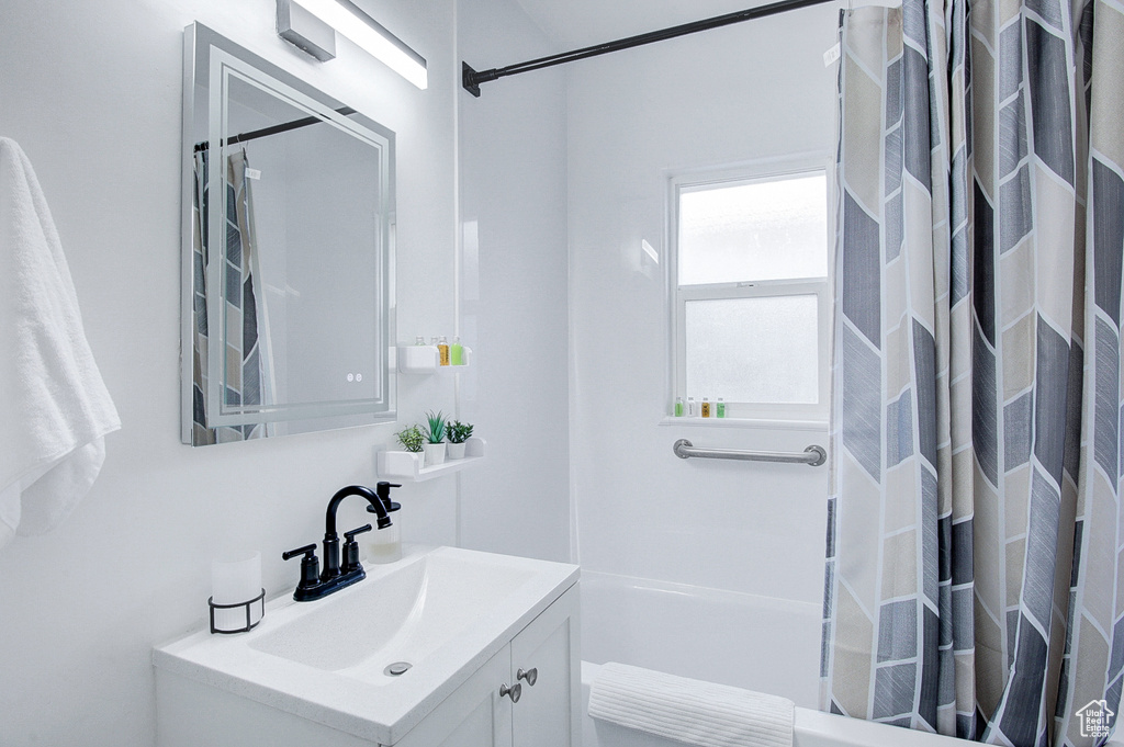 Bathroom with vanity and shower / bath combo with shower curtain