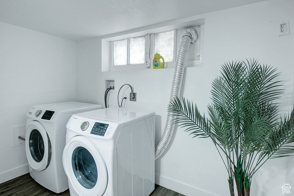 Laundry area with hookup for a washing machine, washing machine and clothes dryer, and dark hardwood / wood-style flooring