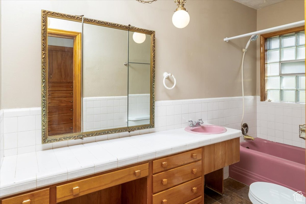 Full bathroom featuring vanity, backsplash, tub / shower combination, tile flooring, and toilet