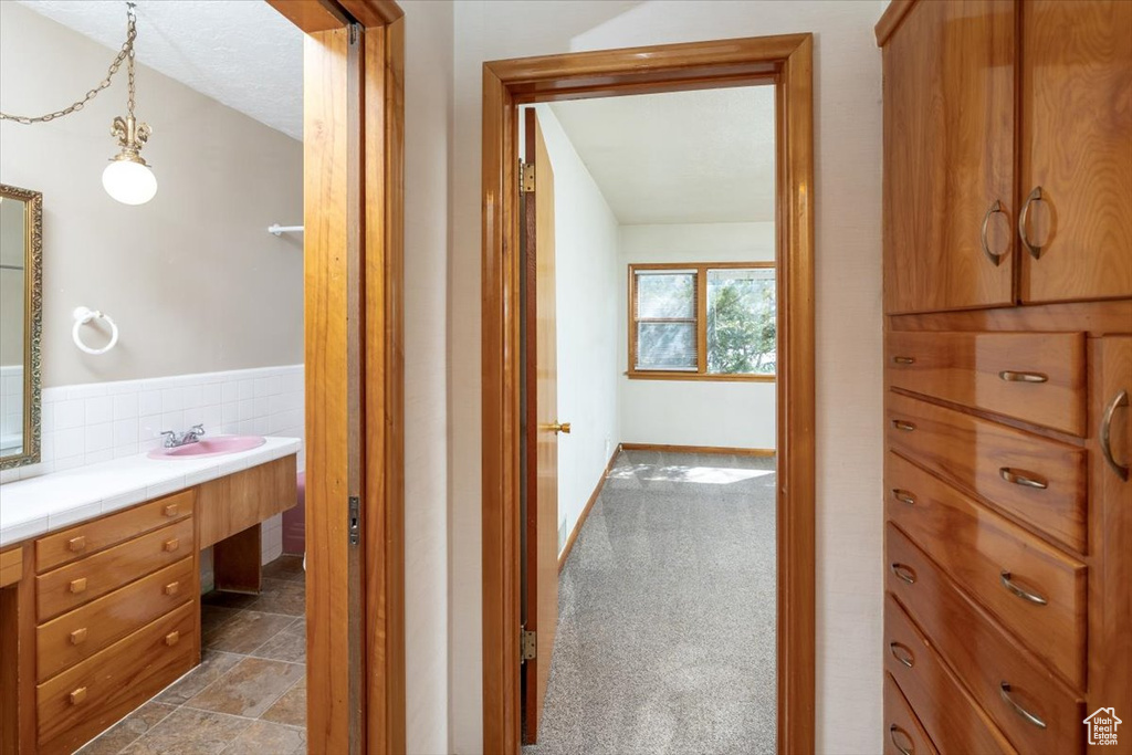 Interior space featuring backsplash, tile floors, and vanity