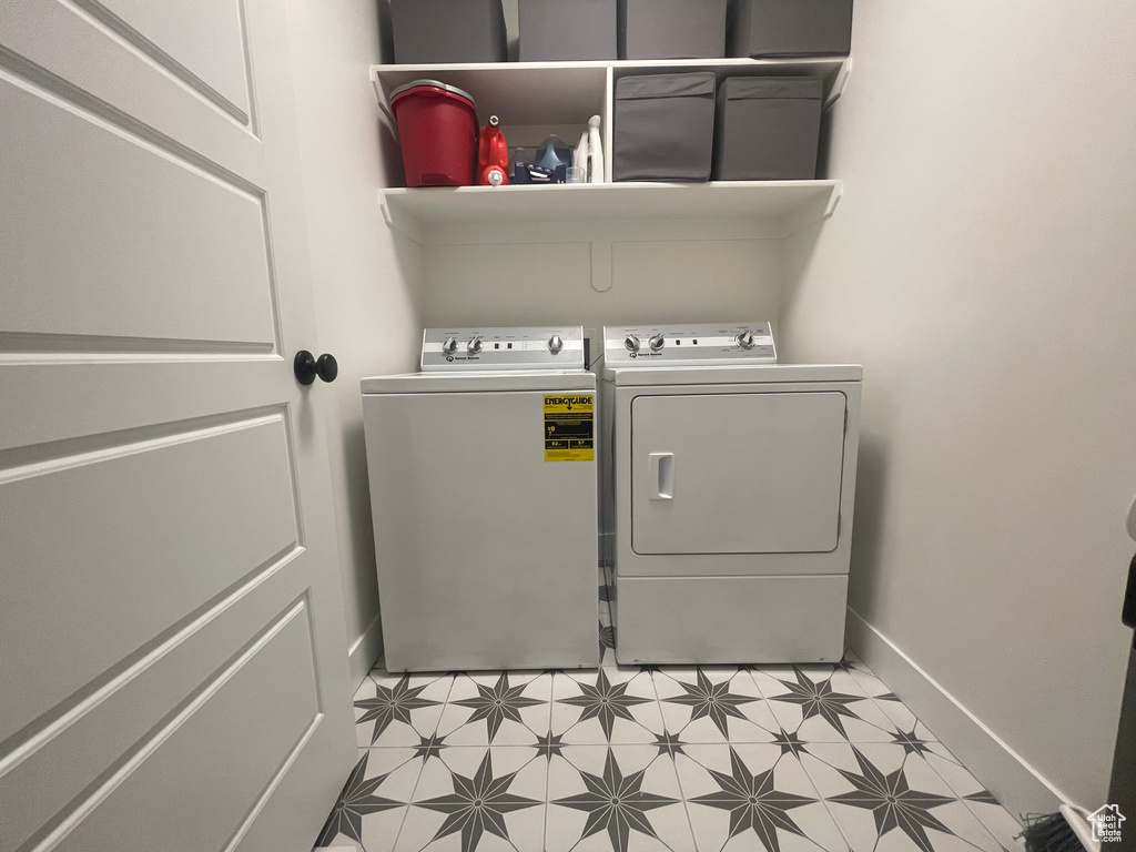 Washroom with washer and dryer and light tile floors