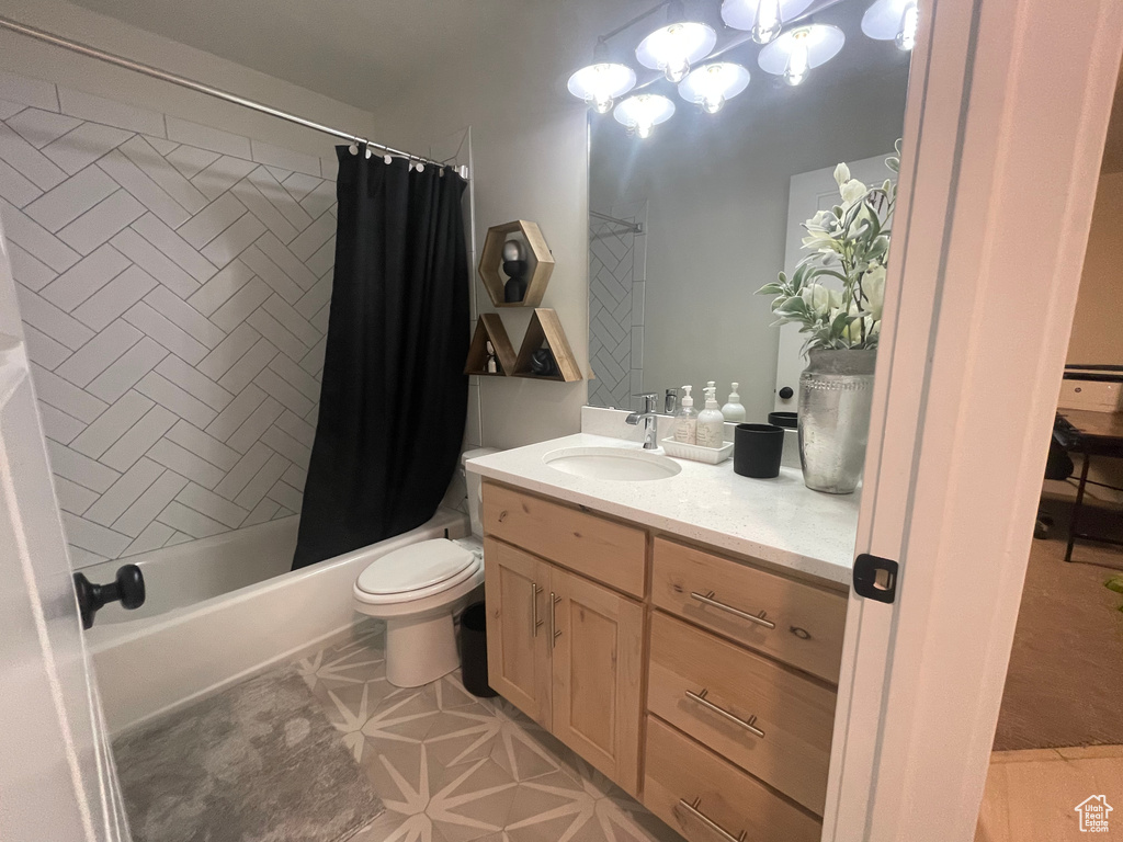 Full bathroom with toilet, large vanity, a notable chandelier, tile flooring, and shower / tub combo
