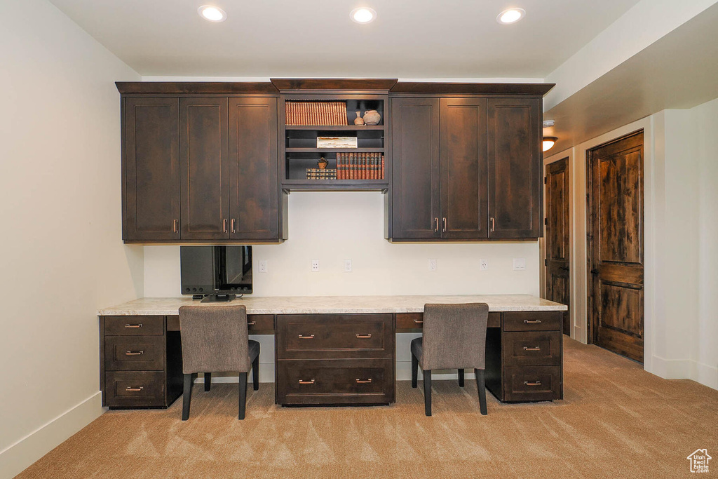 Carpeted home office with built in desk