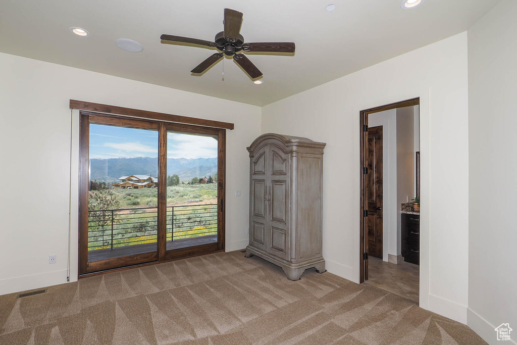 Unfurnished bedroom featuring light carpet and ceiling fan