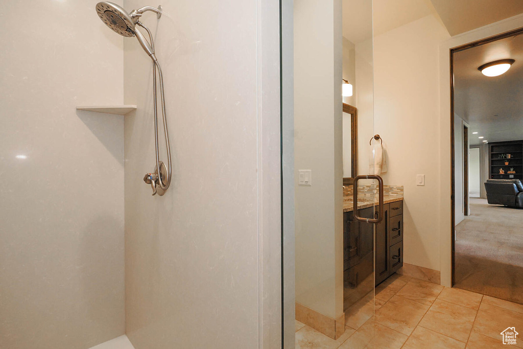 Bathroom with a shower, vanity, and tile flooring