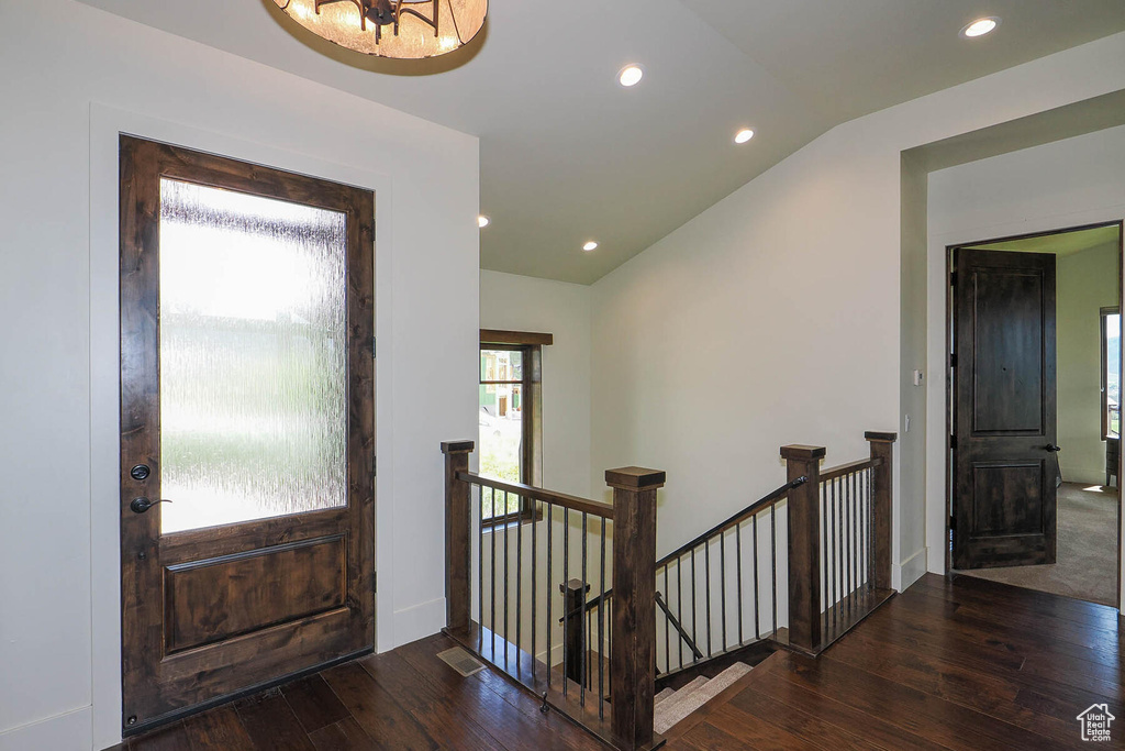 Foyer with lofted ceiling, a chandelier, and dark hardwood / wood-style floors
