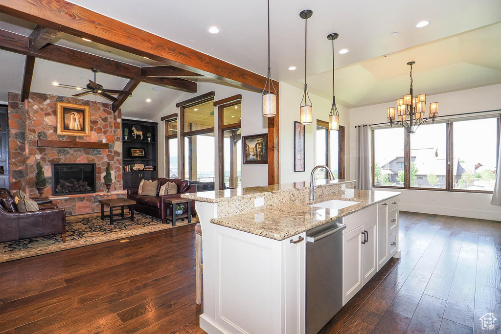 Kitchen featuring decorative light fixtures, sink, an island with sink, white cabinets, and dark hardwood / wood-style flooring