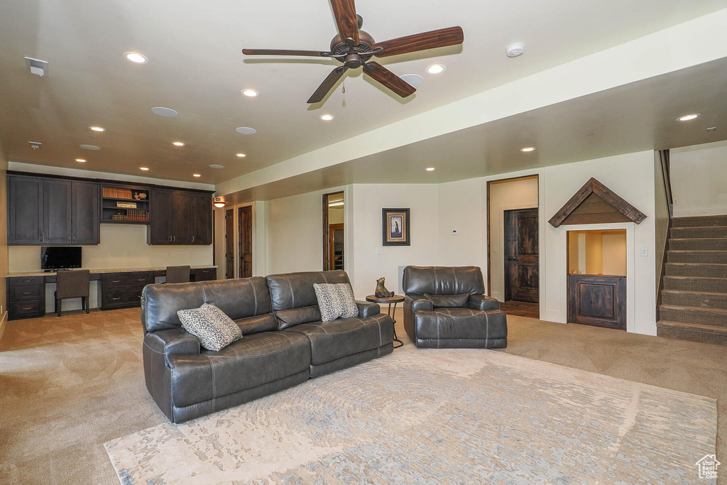 Carpeted living room with ceiling fan