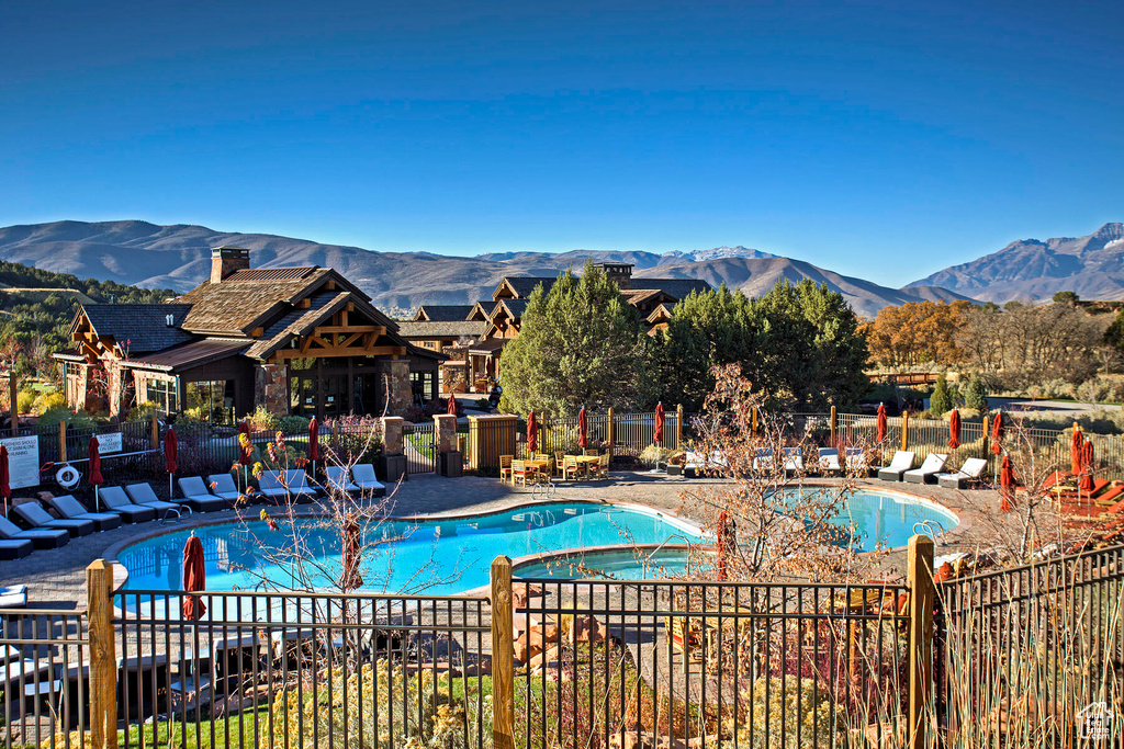 View of swimming pool with a mountain view and a patio