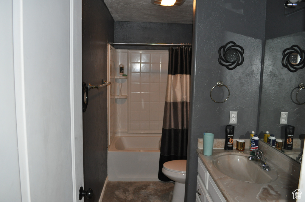 Full bathroom with toilet, vanity with extensive cabinet space, and shower / bath combo