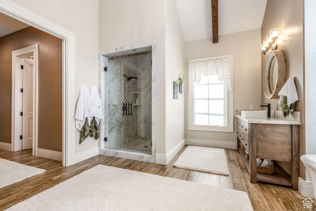 Bathroom with an enclosed shower, vanity, hardwood / wood-style floors, toilet, and lofted ceiling with beams