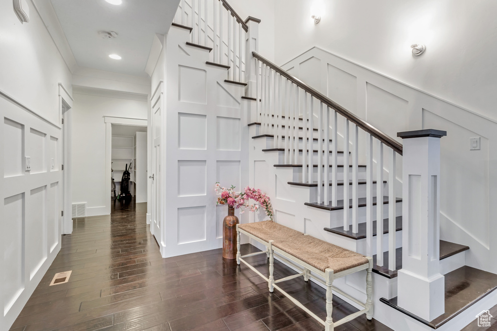 Staircase featuring crown molding and dark hardwood / wood-style floors