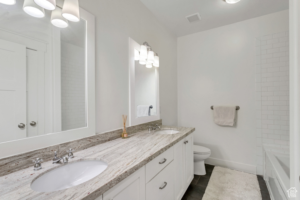Full bathroom with bathtub / shower combination, toilet, dual bowl vanity, and tile flooring
