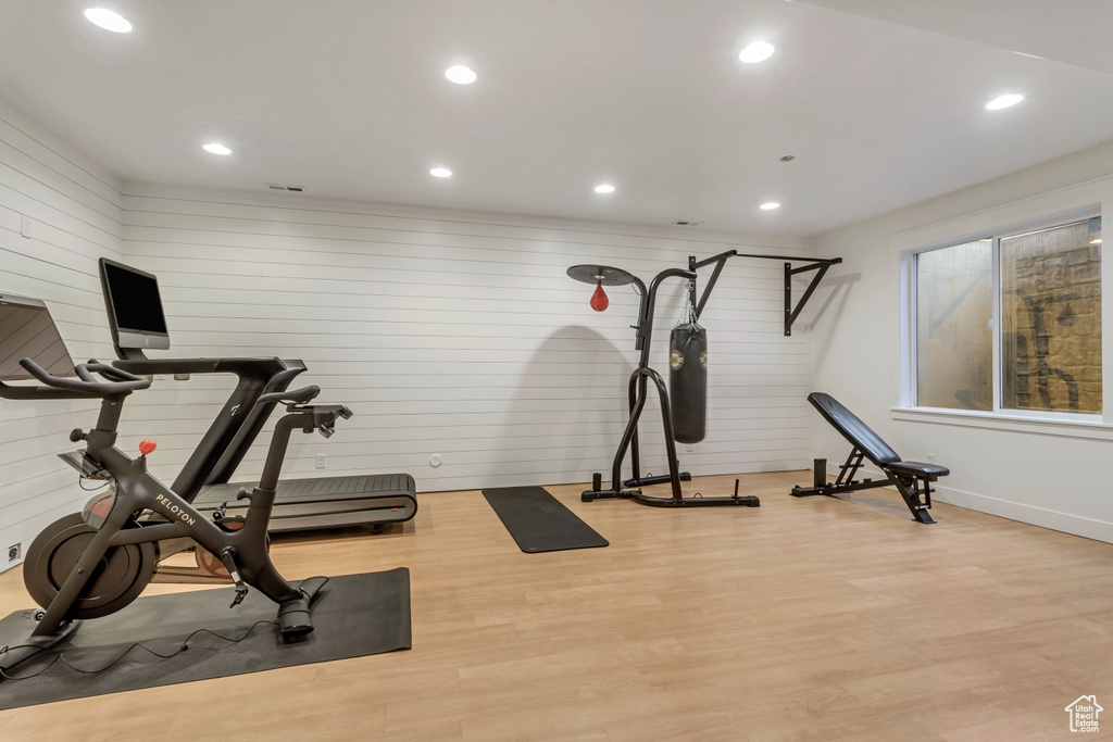 Exercise room featuring wood walls and wood-type flooring