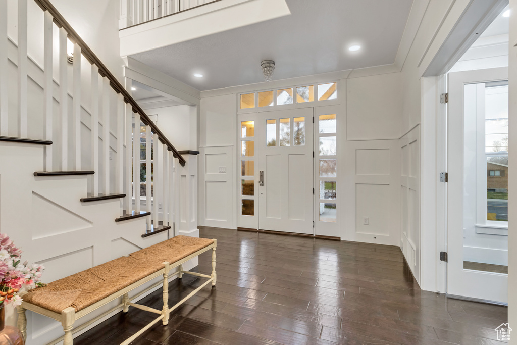 Entrance foyer with crown molding and dark hardwood / wood-style floors