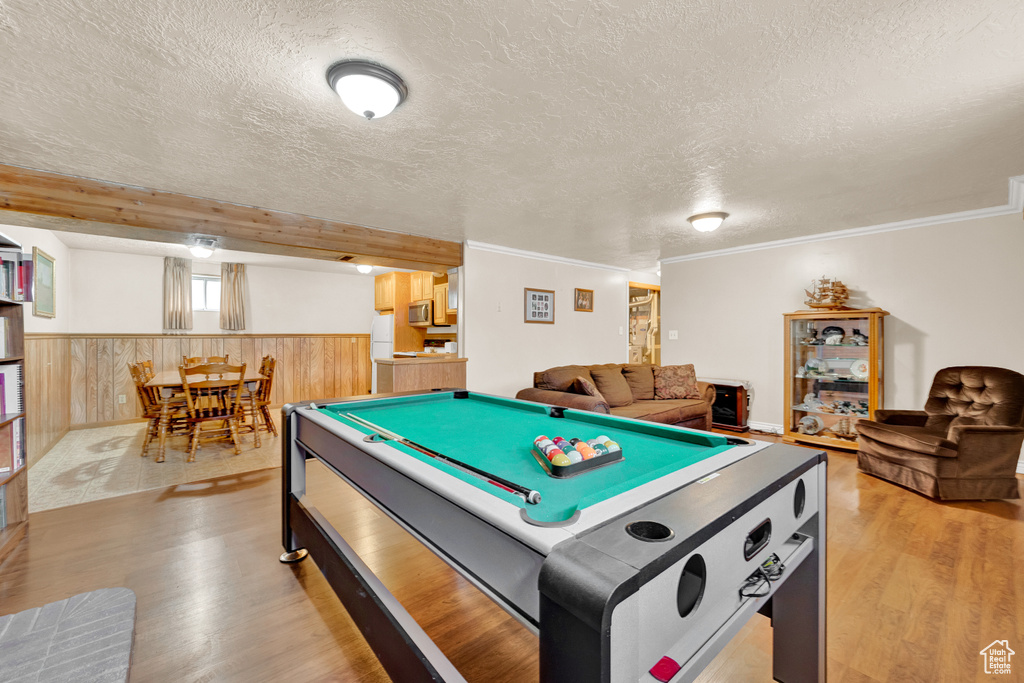 Game room with billiards, a textured ceiling, light hardwood / wood-style floors, and crown molding