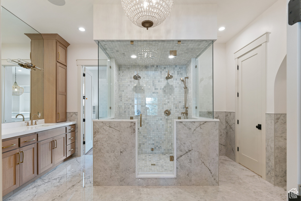 Bathroom with an enclosed shower, vanity, and tile flooring
