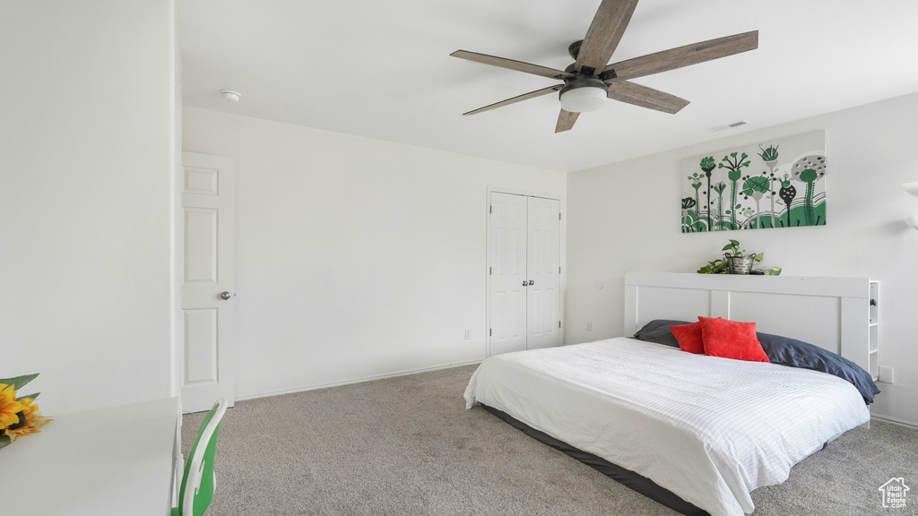 Bedroom featuring a closet, light colored carpet, and ceiling fan
