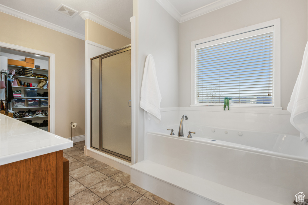 Bathroom featuring shower with separate bathtub, tile flooring, ornamental molding, and vanity