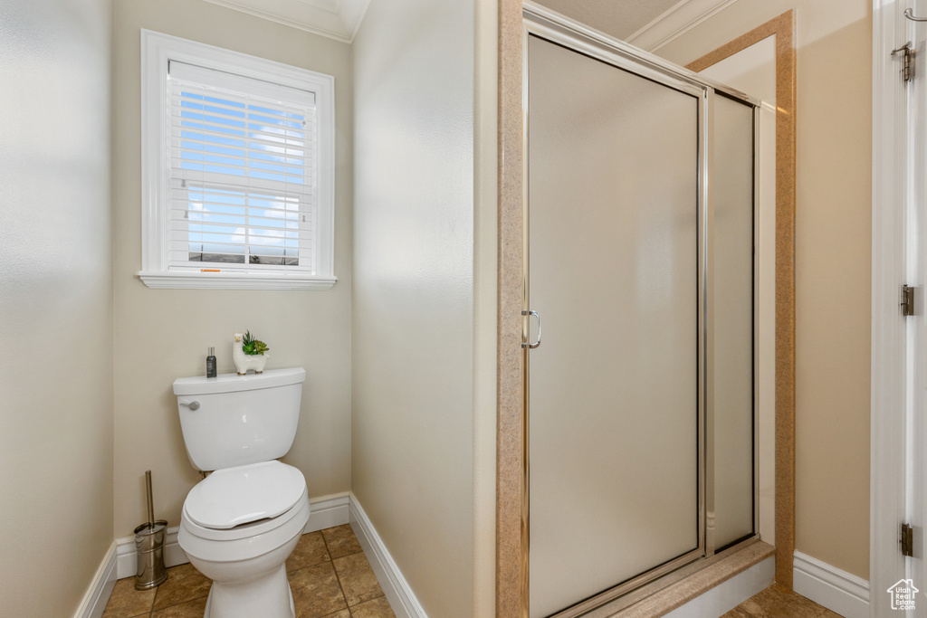 Bathroom with walk in shower, tile floors, crown molding, and toilet