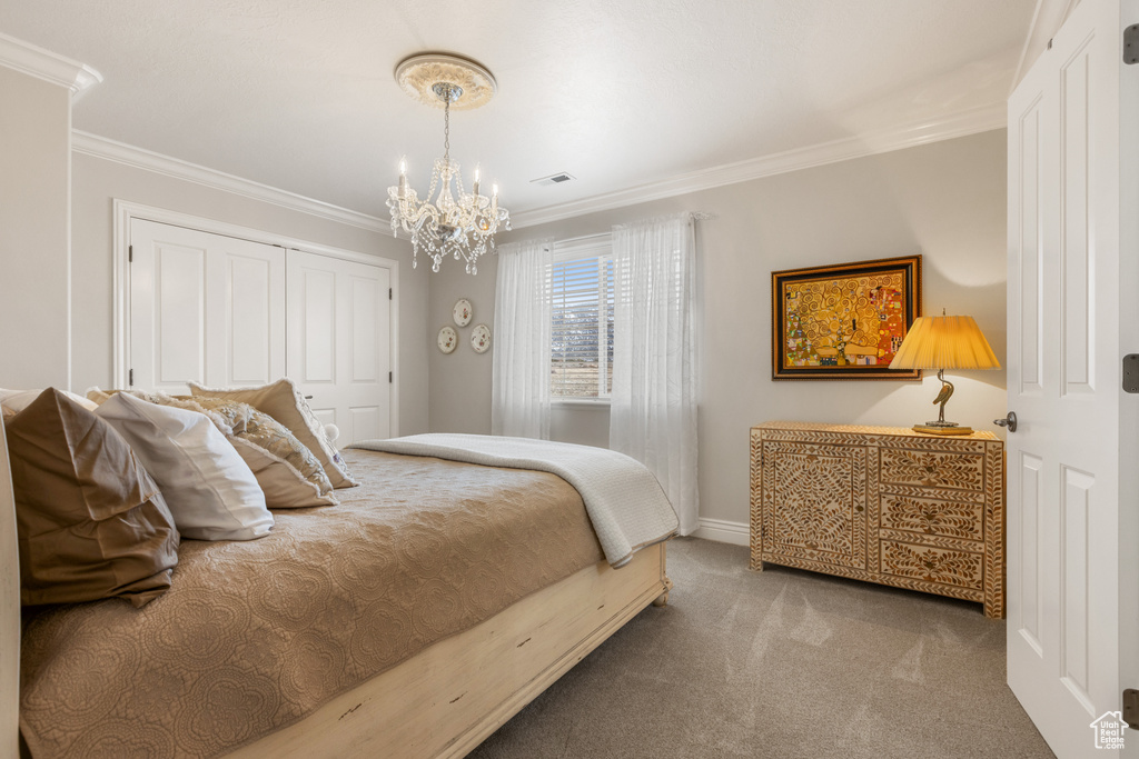 Carpeted bedroom featuring an inviting chandelier, ornamental molding, and a closet