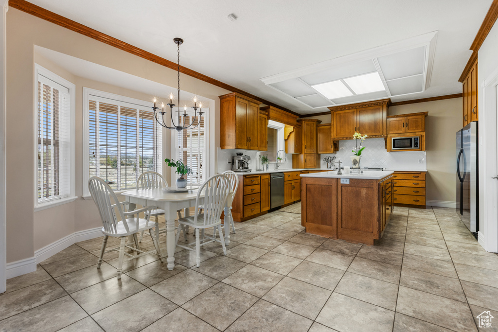 Kitchen featuring light tile flooring, decorative light fixtures, appliances with stainless steel finishes, and an inviting chandelier