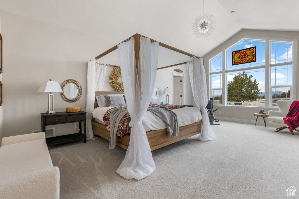 Carpeted bedroom with a chandelier and vaulted ceiling