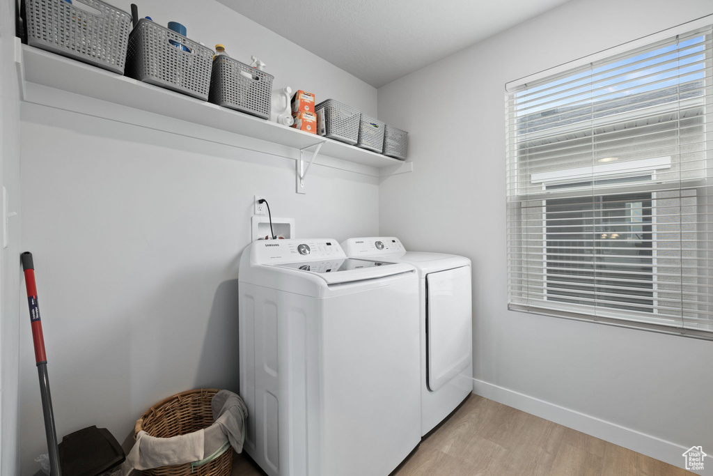 Laundry room featuring washer and clothes dryer, light hardwood / wood-style flooring, and hookup for a washing machine
