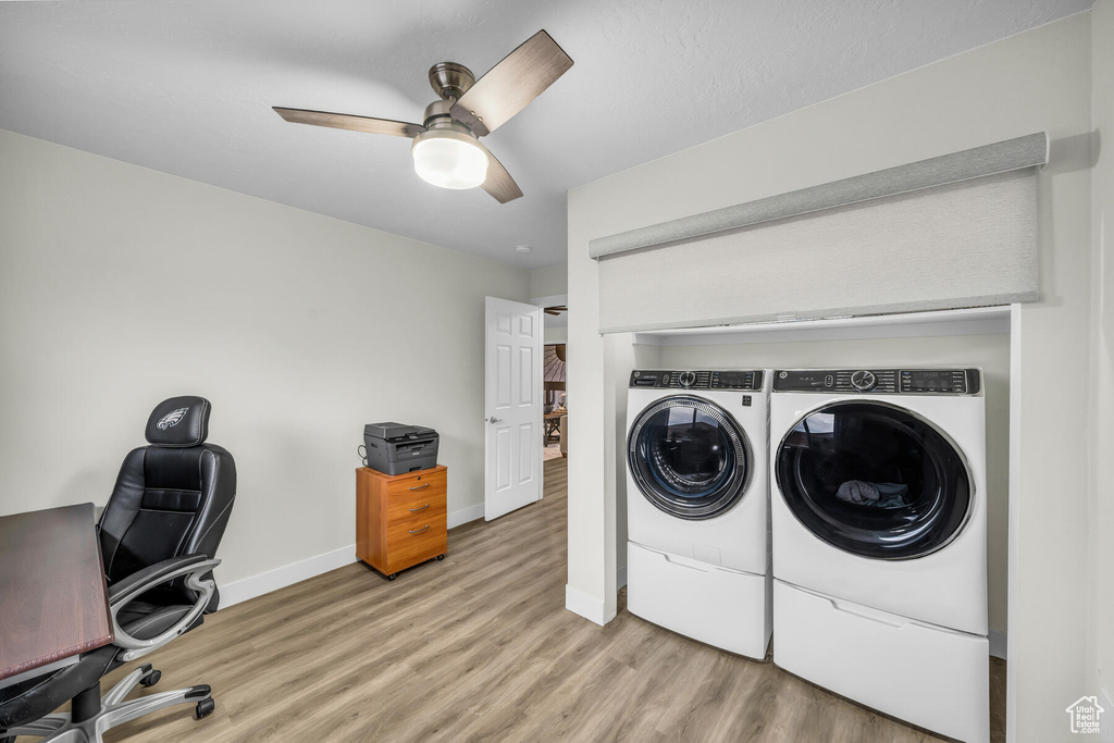 Laundry room featuring separate washer and dryer, ceiling fan, and light wood-type flooring