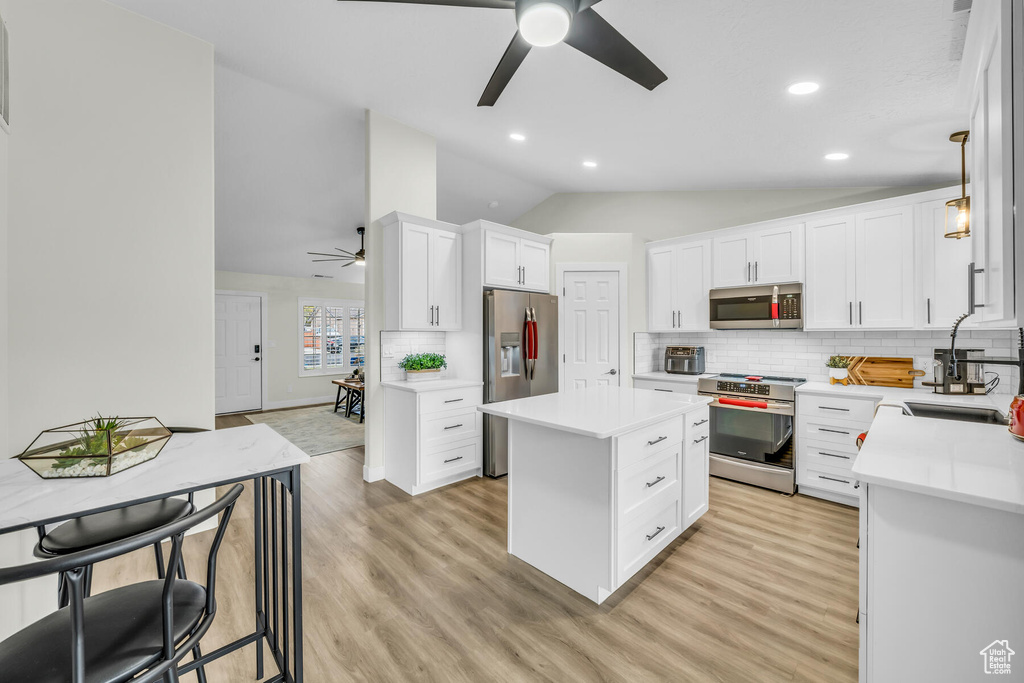 Kitchen with appliances with stainless steel finishes, ceiling fan, and light wood-type flooring