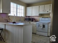 Kitchen featuring white cabinets and white electric stove