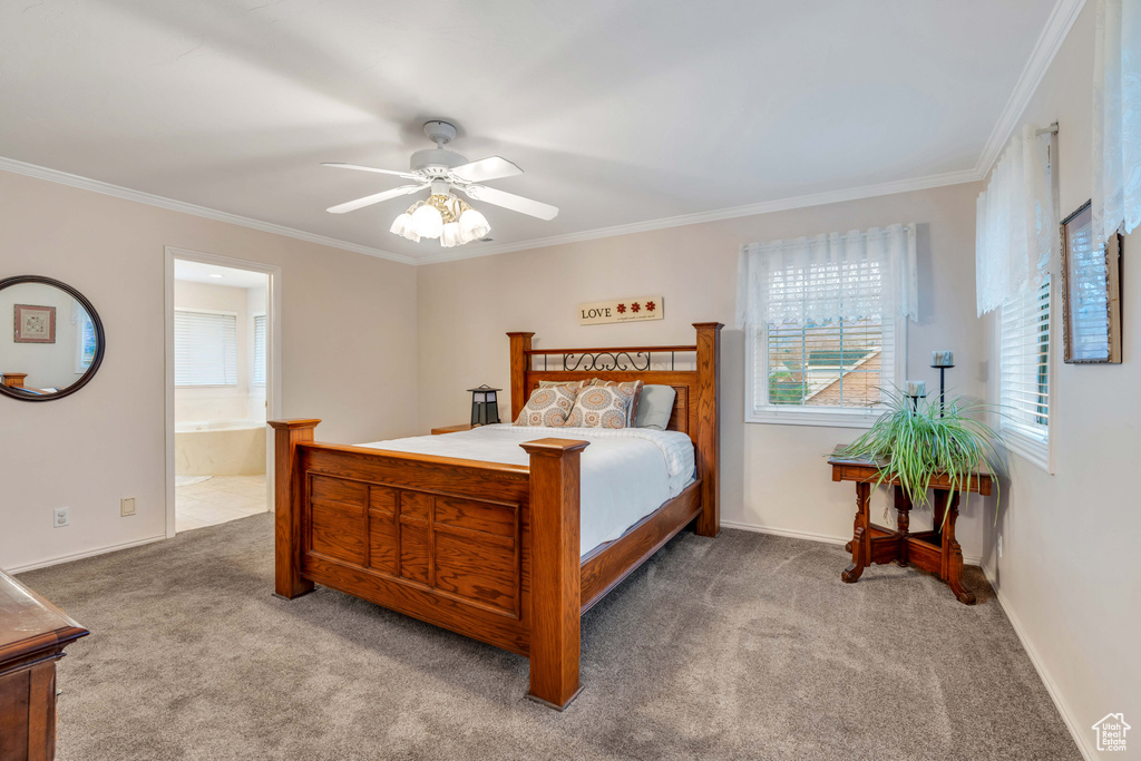 Carpeted bedroom featuring connected bathroom, ornamental molding, and ceiling fan