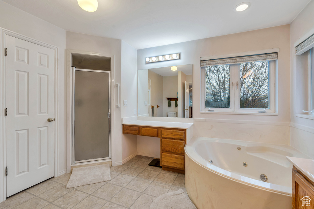 Bathroom featuring vanity, tile floors, and separate shower and tub