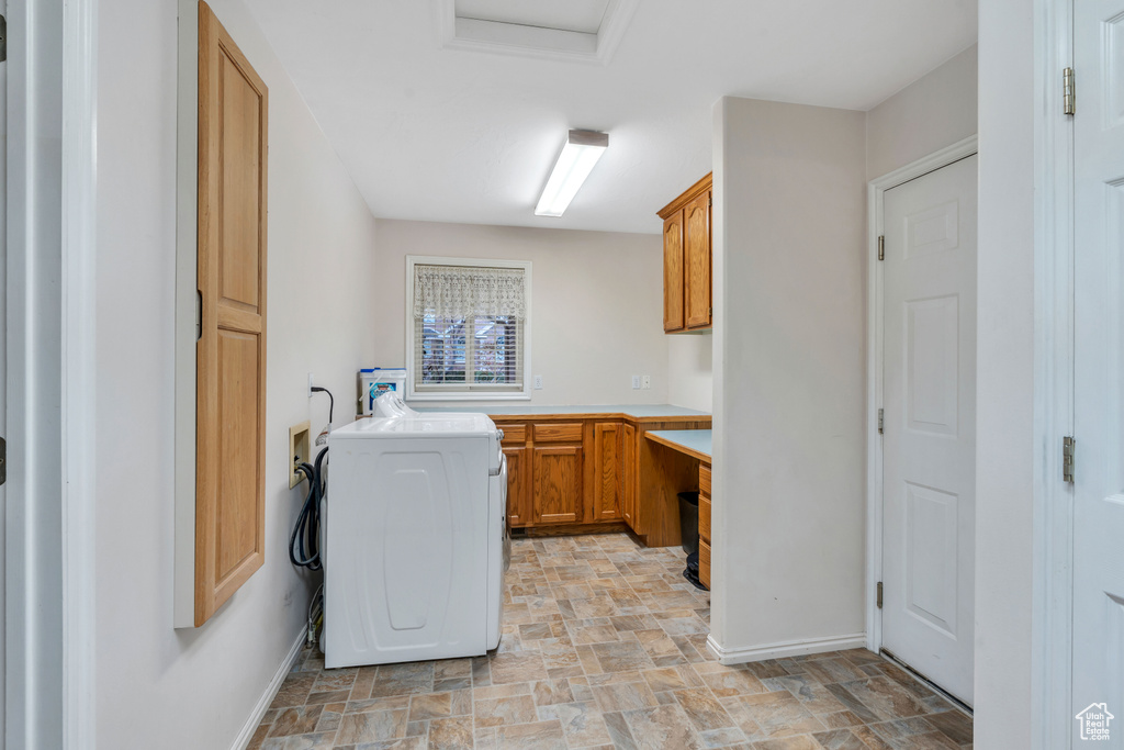 Laundry area with light tile floors, cabinets, and washer / dryer