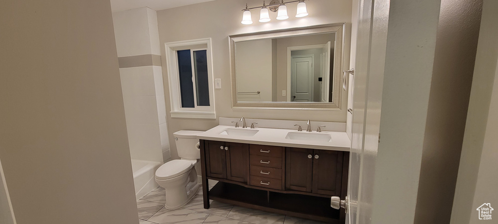 Full bathroom with tile floors, toilet, dual vanity, and bathing tub / shower combination