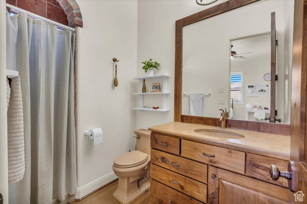 Bathroom featuring toilet, ceiling fan, and vanity