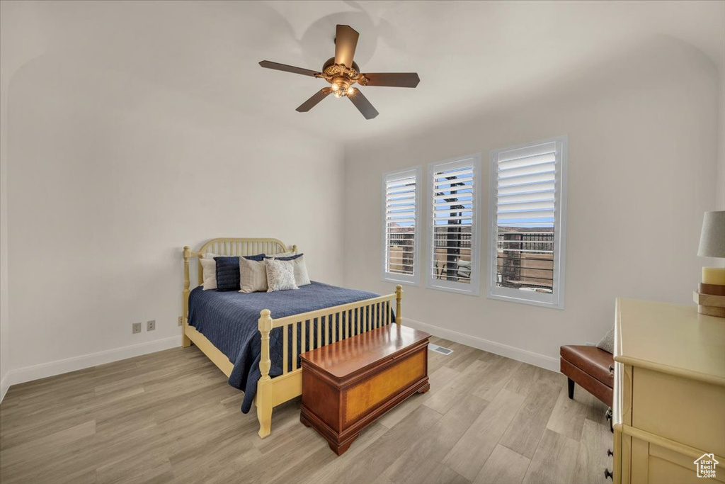 Bedroom with light hardwood / wood-style floors and ceiling fan