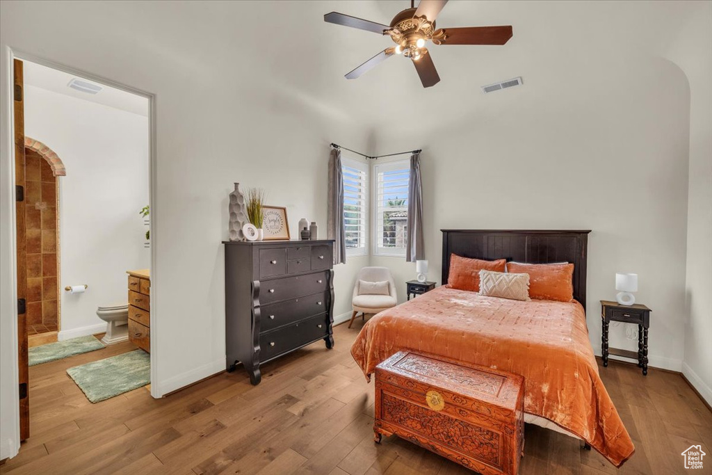 Bedroom featuring ensuite bath, hardwood / wood-style floors, and ceiling fan