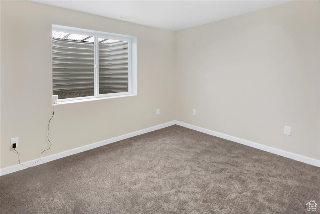 Carpeted spare room featuring a healthy amount of sunlight